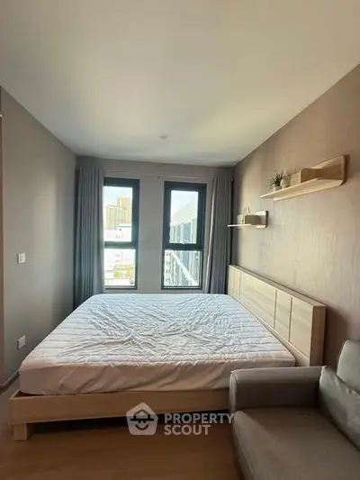 Modern bedroom with large windows and minimalist decor in urban apartment