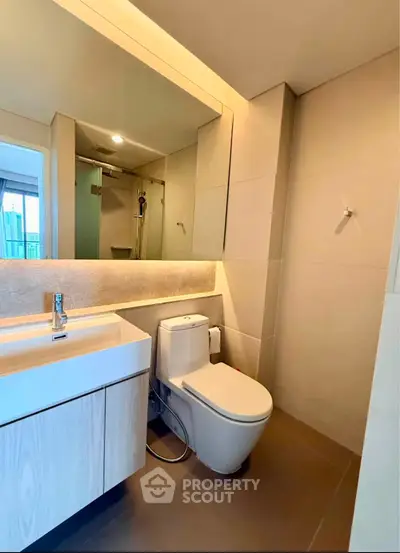 Modern bathroom with sleek fixtures and spacious shower in a contemporary apartment.