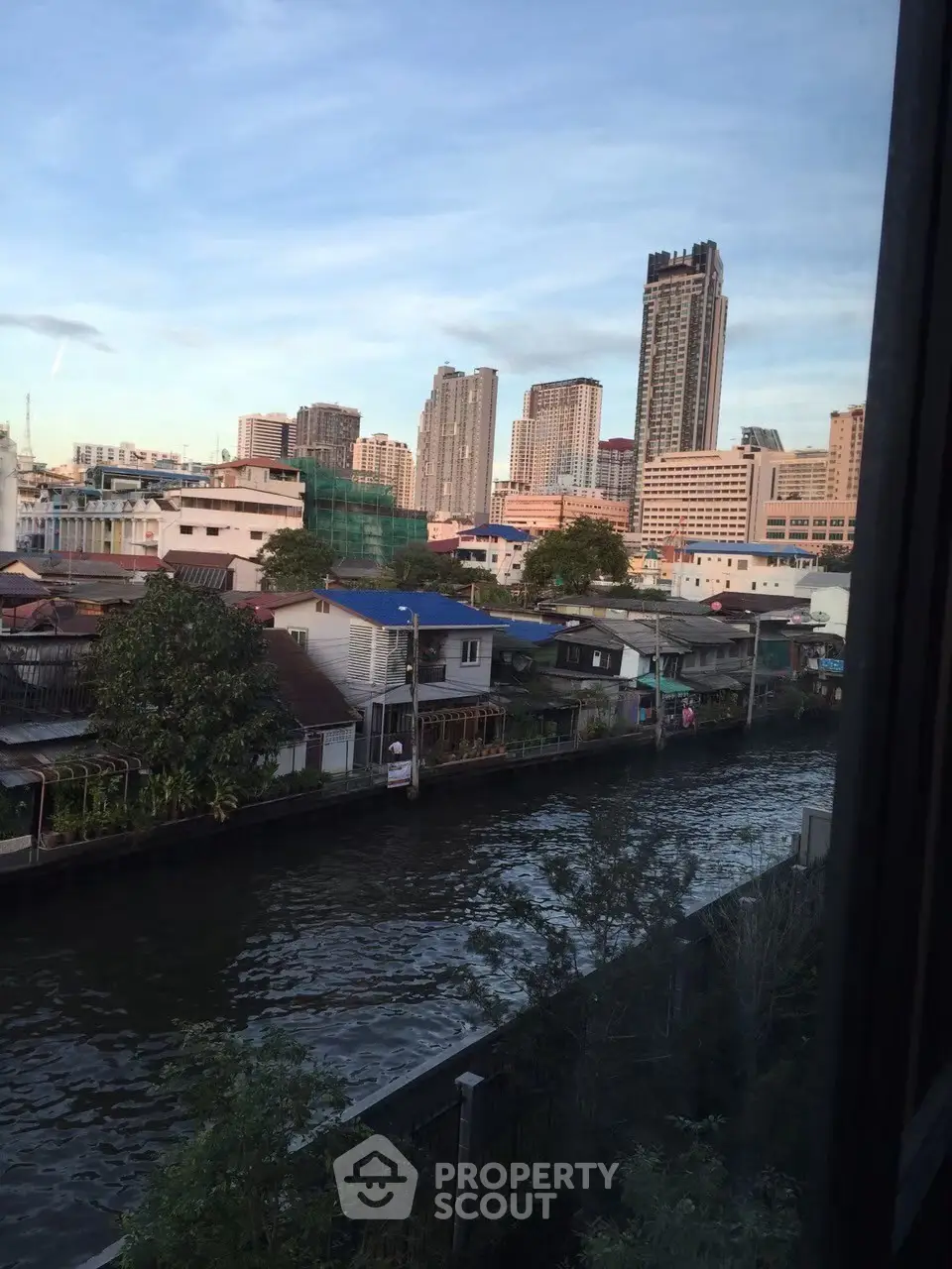 Stunning urban canal view with high-rise buildings in the background, perfect for city living enthusiasts.