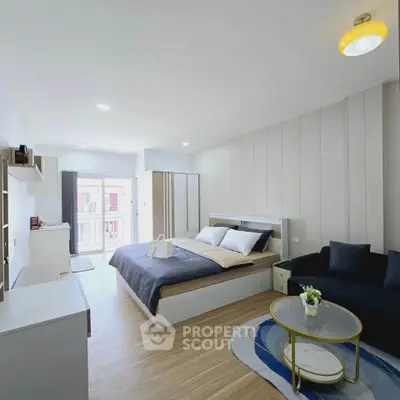 Spacious modern bedroom with cozy seating area and stylish decor