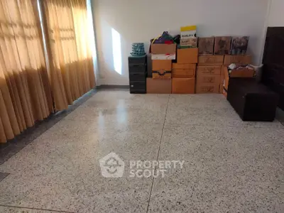 Spacious room with tiled floor and stacked moving boxes, ideal for storage or conversion.