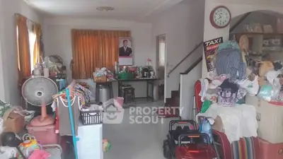 Spacious living room with cluttered decor and natural light, ideal for creative renovation.