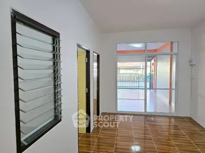 Spacious modern interior with sleek tile flooring and large windows for natural light.