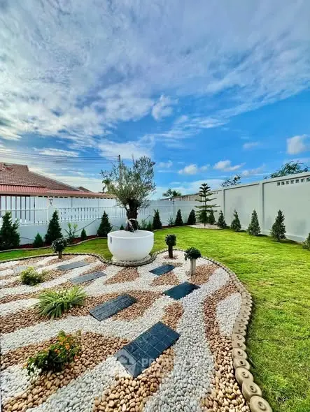 Stunning landscaped garden with modern design and lush greenery under a vibrant blue sky.