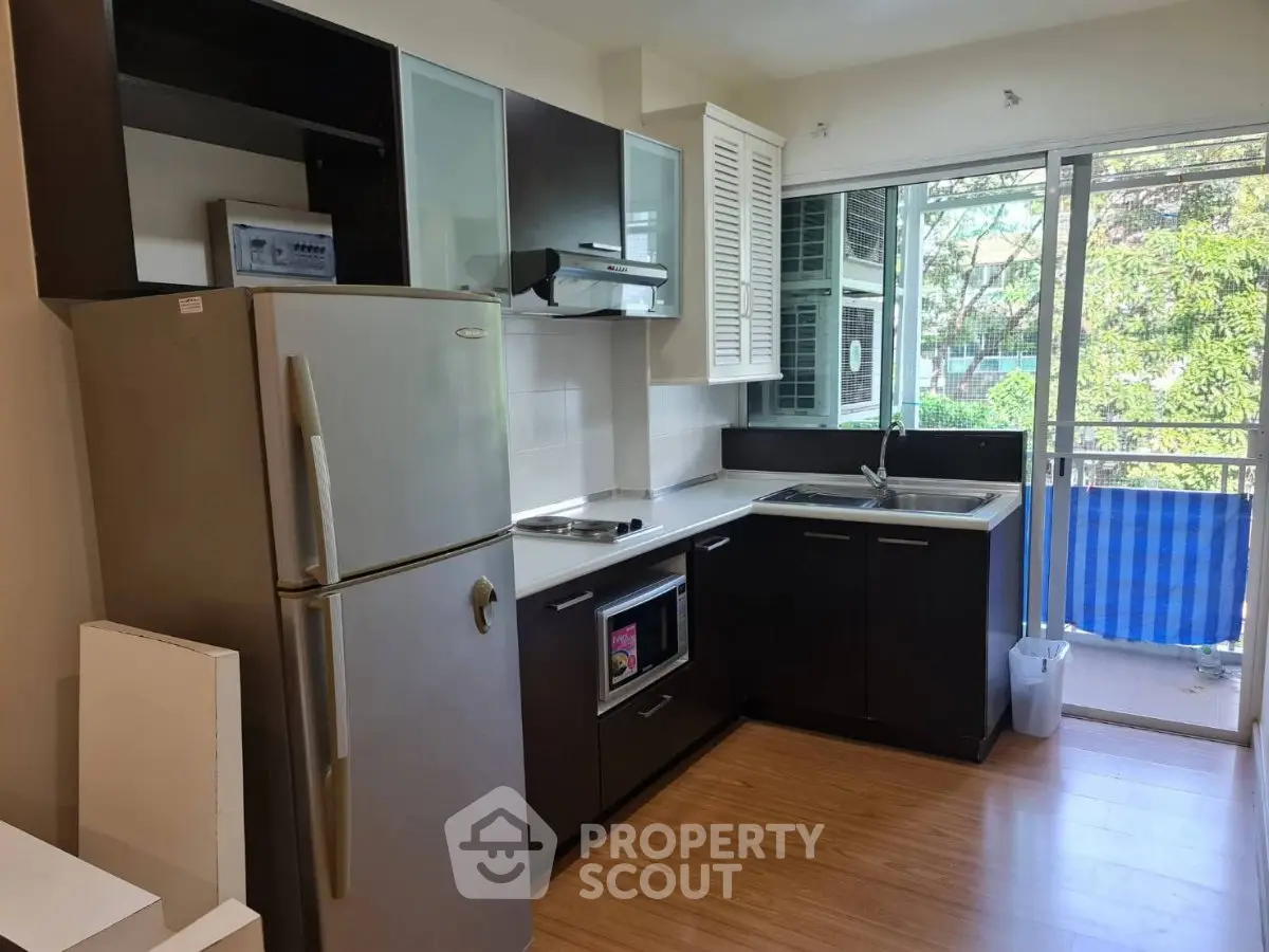 Modern kitchen with sleek appliances and balcony view, perfect for urban living.
