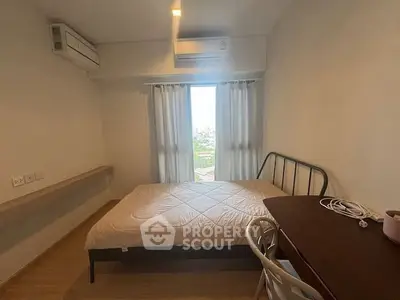 Cozy bedroom with natural light and modern furnishings, ideal for relaxation.