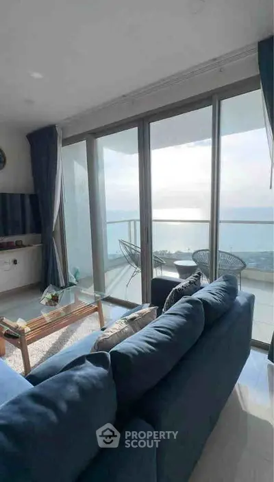 Stunning living room with ocean view and spacious balcony in modern apartment.
