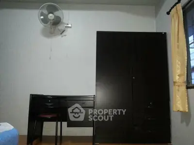 Cozy bedroom with dark wood furniture and wall-mounted fan