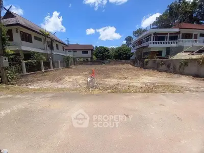 Prime residential land for sale in a serene neighborhood with clear blue skies and lush surroundings.
