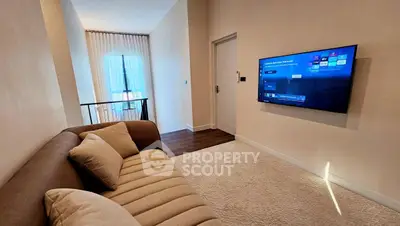 Modern living room with cozy sofa and wall-mounted TV in stylish apartment.