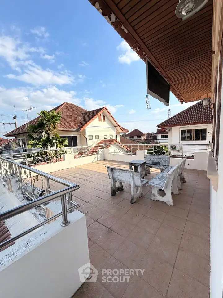 Spacious rooftop terrace with seating and scenic views in a charming residential area.