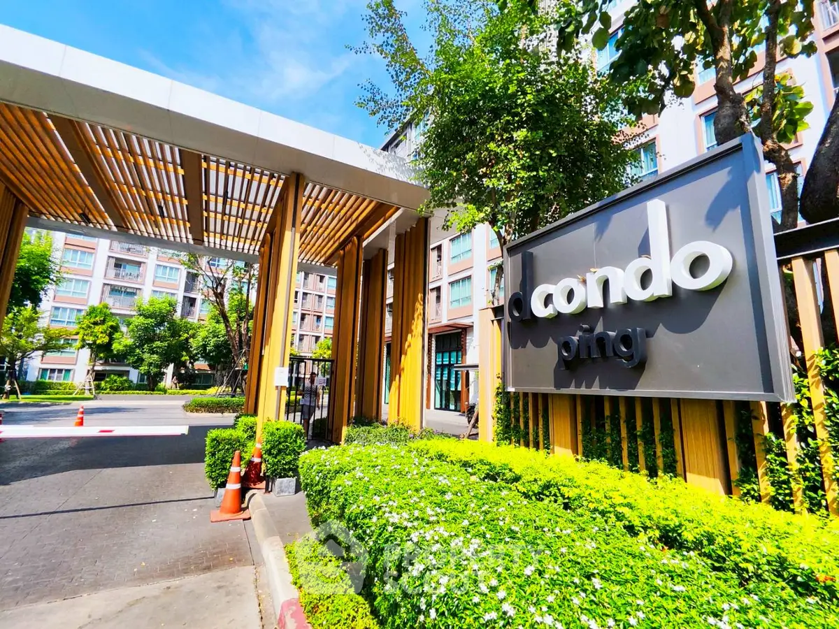 Modern condo entrance with lush greenery and stylish signage