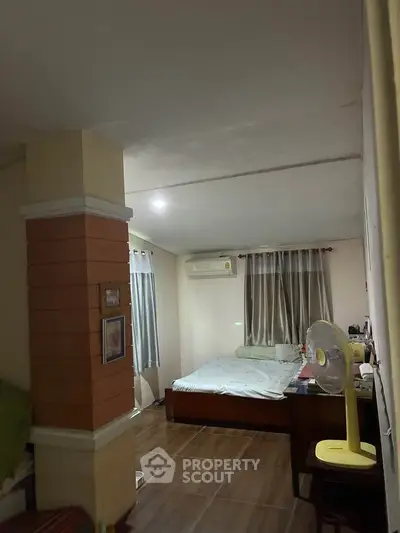 Cozy bedroom with air conditioning and wooden flooring, perfect for a comfortable living experience.