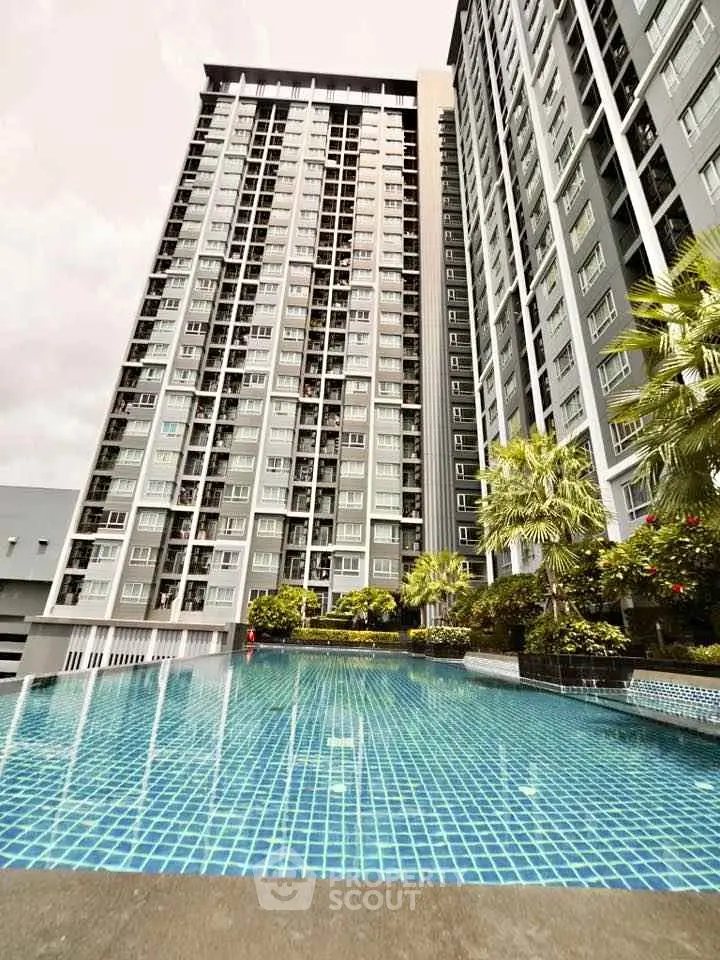 Stunning high-rise building with luxurious pool and lush greenery, perfect for modern urban living.