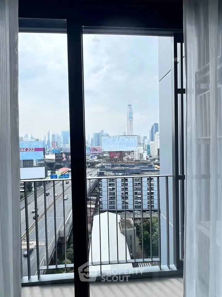 Stunning city view from a modern apartment balcony with floor-to-ceiling windows.