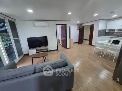 Spacious open-plan living room and kitchen with modern furnishings and natural light.