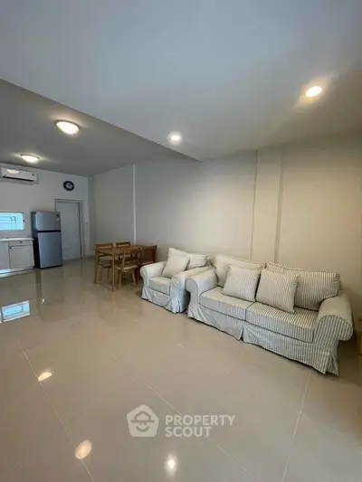 Spacious living room with modern furniture and open kitchen layout