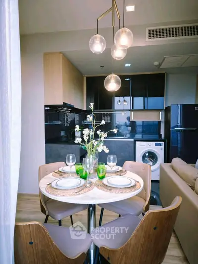 Modern kitchen with dining area, featuring sleek appliances and elegant lighting.