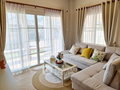 Bright and cozy living room with large windows and stylish decor, perfect for relaxation.