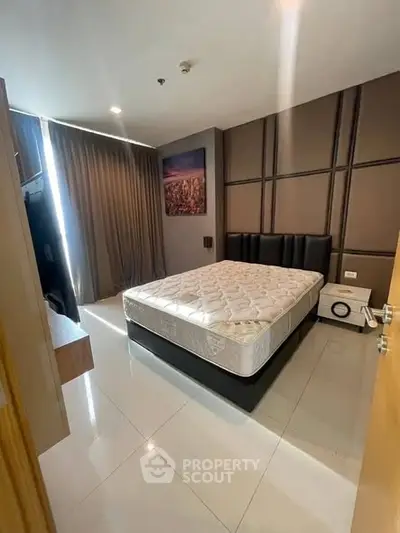 Modern bedroom with stylish decor and natural light, featuring a comfortable bed and sleek flooring.