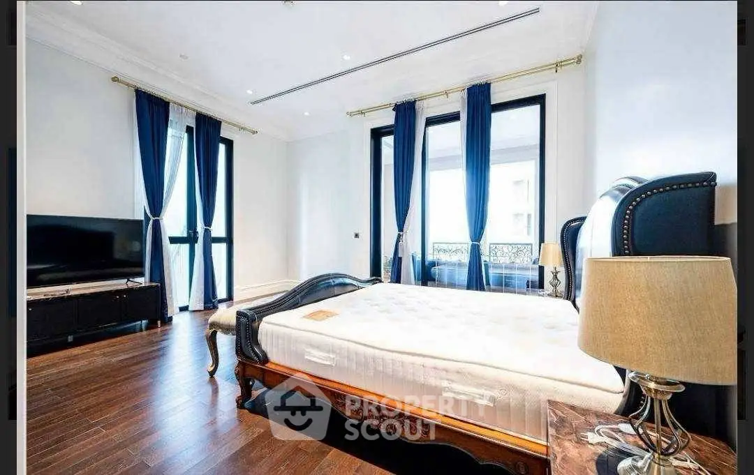 Luxurious bedroom with elegant decor, hardwood floors, and large windows for natural light.