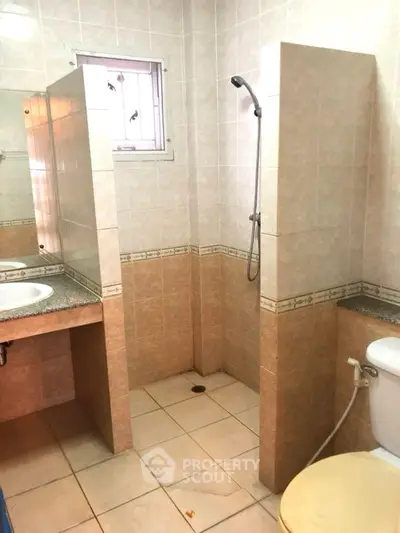 Spacious bathroom with dual sinks and open shower design.