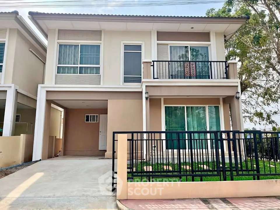 Modern two-story house with balcony and driveway in a suburban neighborhood.