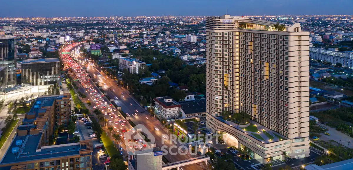 Stunning aerial view of a modern high-rise building with cityscape at dusk, showcasing urban living.