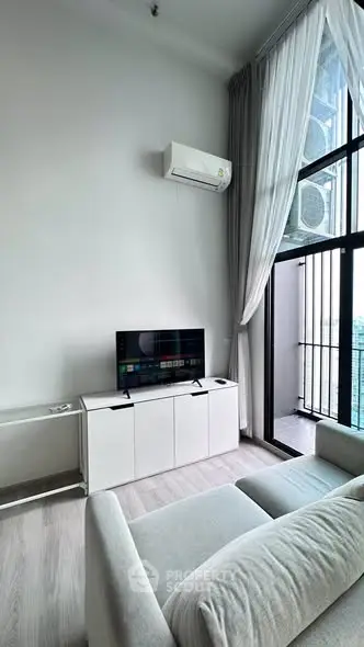 Modern living room with sleek furniture and balcony view in high-rise apartment.