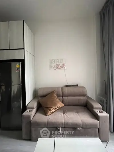 Modern living room with stylish sofa and sleek refrigerator