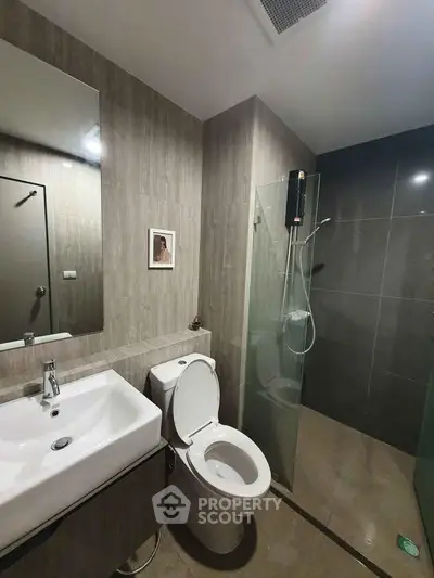 Modern bathroom with sleek design, featuring a glass shower enclosure and stylish fixtures.
