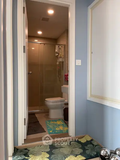 Modern bathroom with glass shower and stylish decor in a cozy apartment.