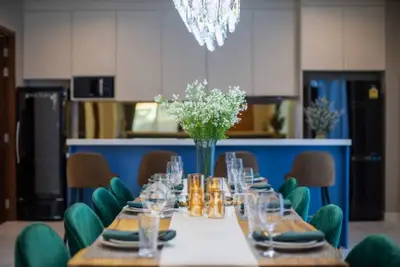 Luxurious dining area with elegant table setting and modern kitchen backdrop.