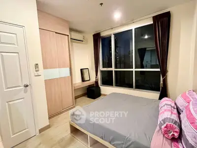 Cozy bedroom with large window and modern furnishings in a stylish apartment.