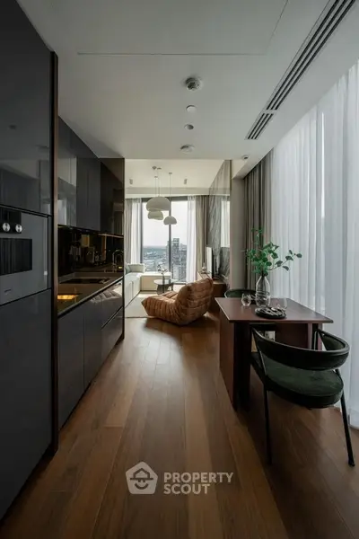 Modern open-plan living room with sleek kitchen and panoramic city view, featuring stylish furniture and elegant decor.