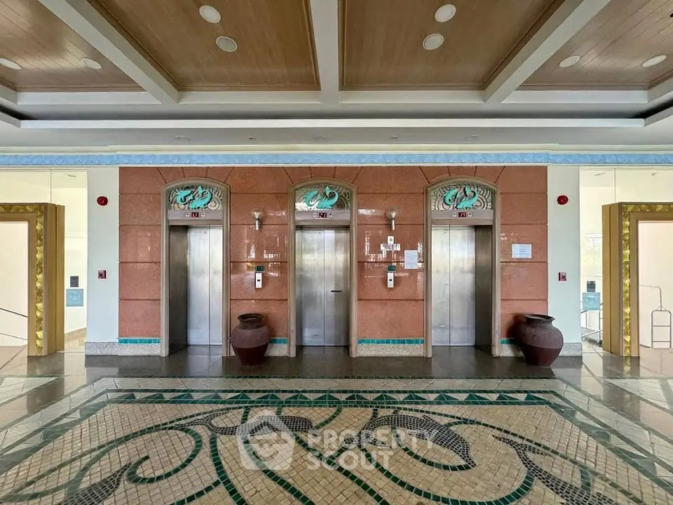 Elegant building lobby with three elevators and intricate floor design