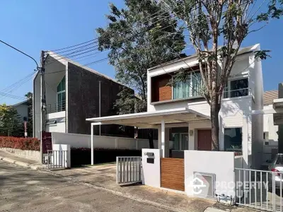 Modern two-story house with sleek design and spacious driveway in a serene neighborhood.