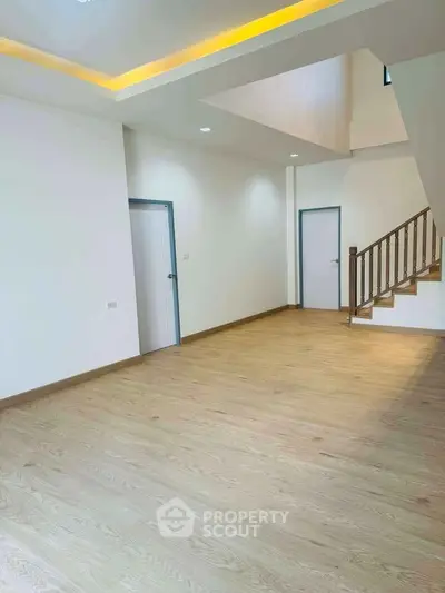 Spacious modern living room with wooden flooring and staircase