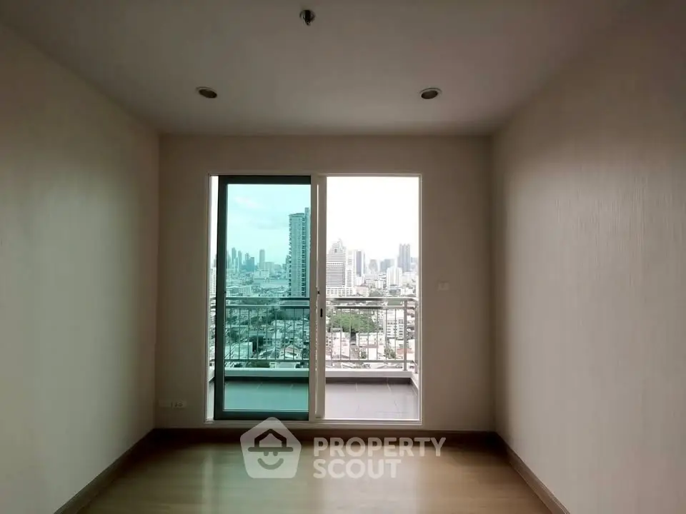 Spacious empty room with city view and balcony access in modern apartment