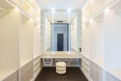 Luxurious walk-in closet with ample shelving and elegant lighting