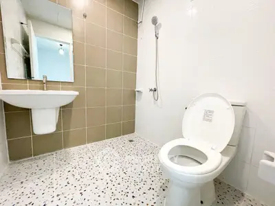 Modern bathroom with sleek design and neutral tones, featuring a shower and stylish sink.
