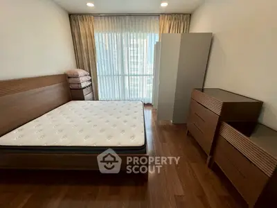 Modern bedroom with wooden furniture and large window in a stylish apartment.