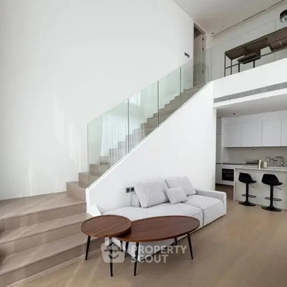Modern duplex living room with sleek staircase and open kitchen layout