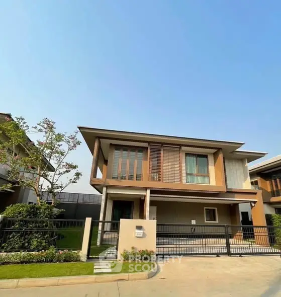 Modern two-story house with sleek design and lush garden in a serene neighborhood.