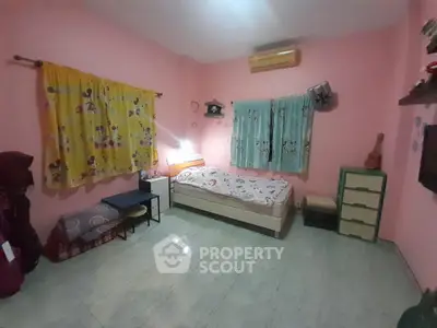 Cozy bedroom with colorful curtains and simple decor, perfect for relaxation.