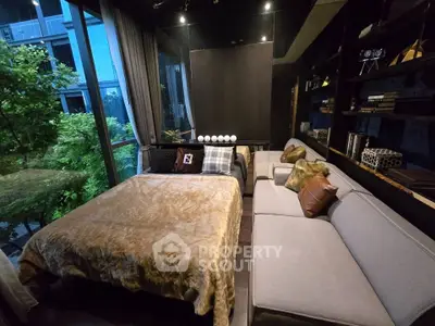 Luxurious bedroom with modern decor and large window overlooking greenery, featuring a cozy bed and stylish sofa.
