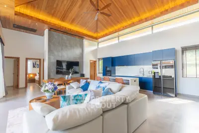 Luxurious open-plan living room with modern kitchen and high wooden ceiling