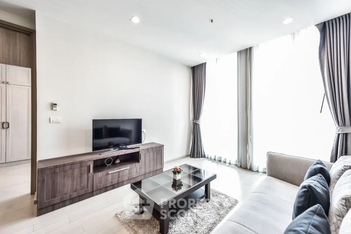 Modern living room with sleek furniture and large windows for natural light.