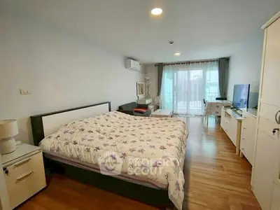 Spacious bedroom with modern decor and balcony access in a stylish apartment.