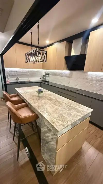 Modern kitchen with marble island and stylish lighting in open layout design